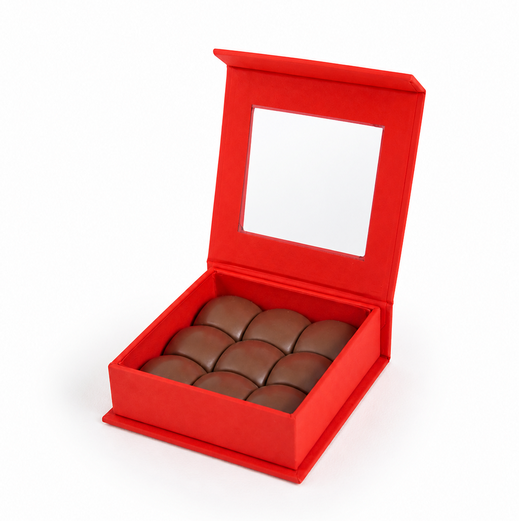    Open box of pistachio praline chocolate domes by La Belg
